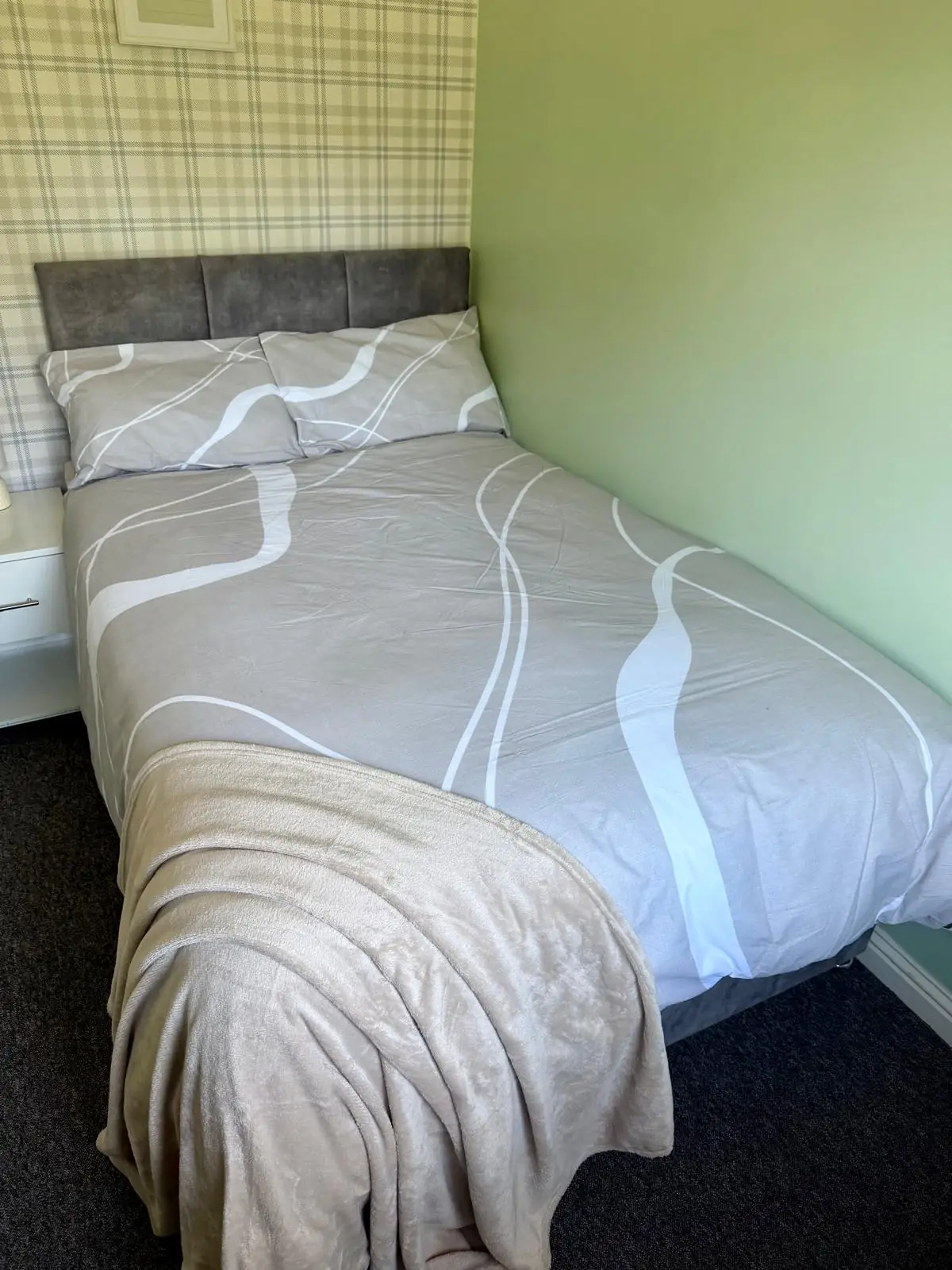 Bedroom with neutral bedding and blanket
