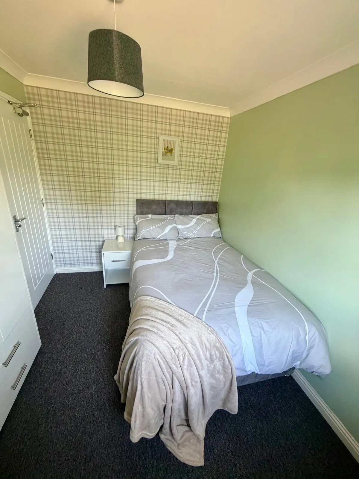 Bedroom with neutral bedding and bedside table